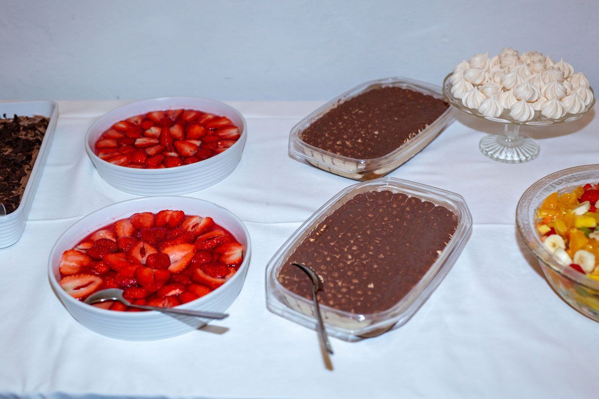 Dessertbuffet mit Schüsseln voller Erdbeeren, cremiger Schokolade und Schlagsahne auf einem Tisch
