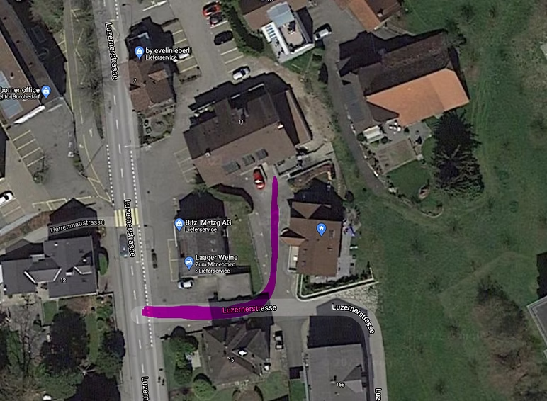 Satellitenansicht einer Wohnstraße mit einer magentafarbenen Route zwischen Gebäuden und einem Parkplatz