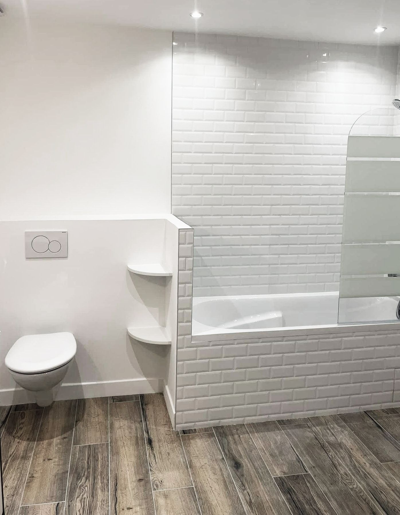 Salle de bains rénovée avec baignoire blanche et faïence