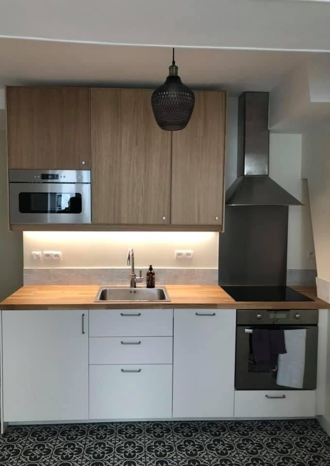 Cuisine moderne avec des meubles en bois et blancs et un sol en carrelage