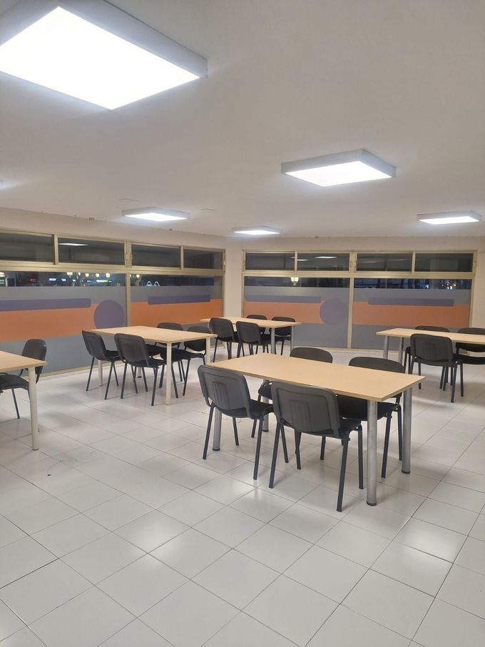 Estudiantes en una sala de conferencias escuchando atentamente, algunos tomando notas.