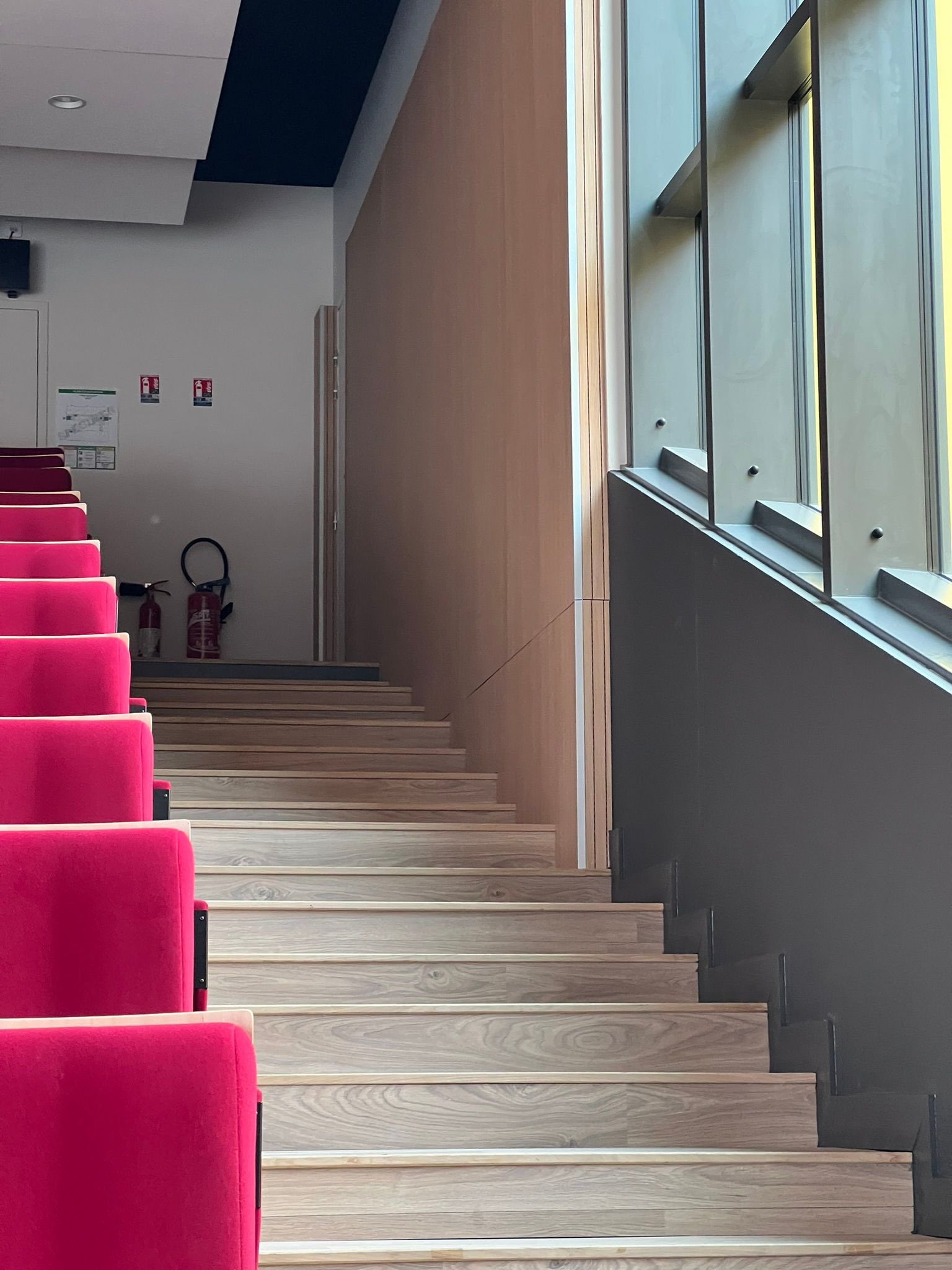 Escalier à côté de sièges dans un couloir intérieur.