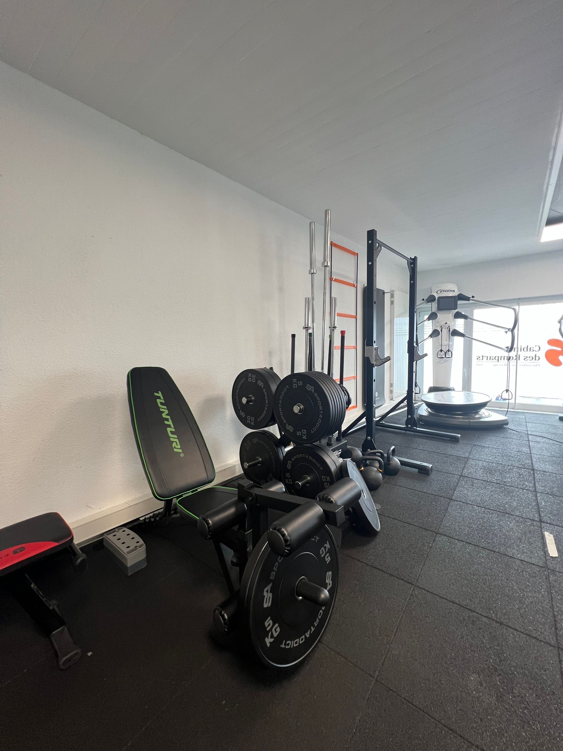 Une machine de musculation avec des poids et un banc dans une salle de sport.