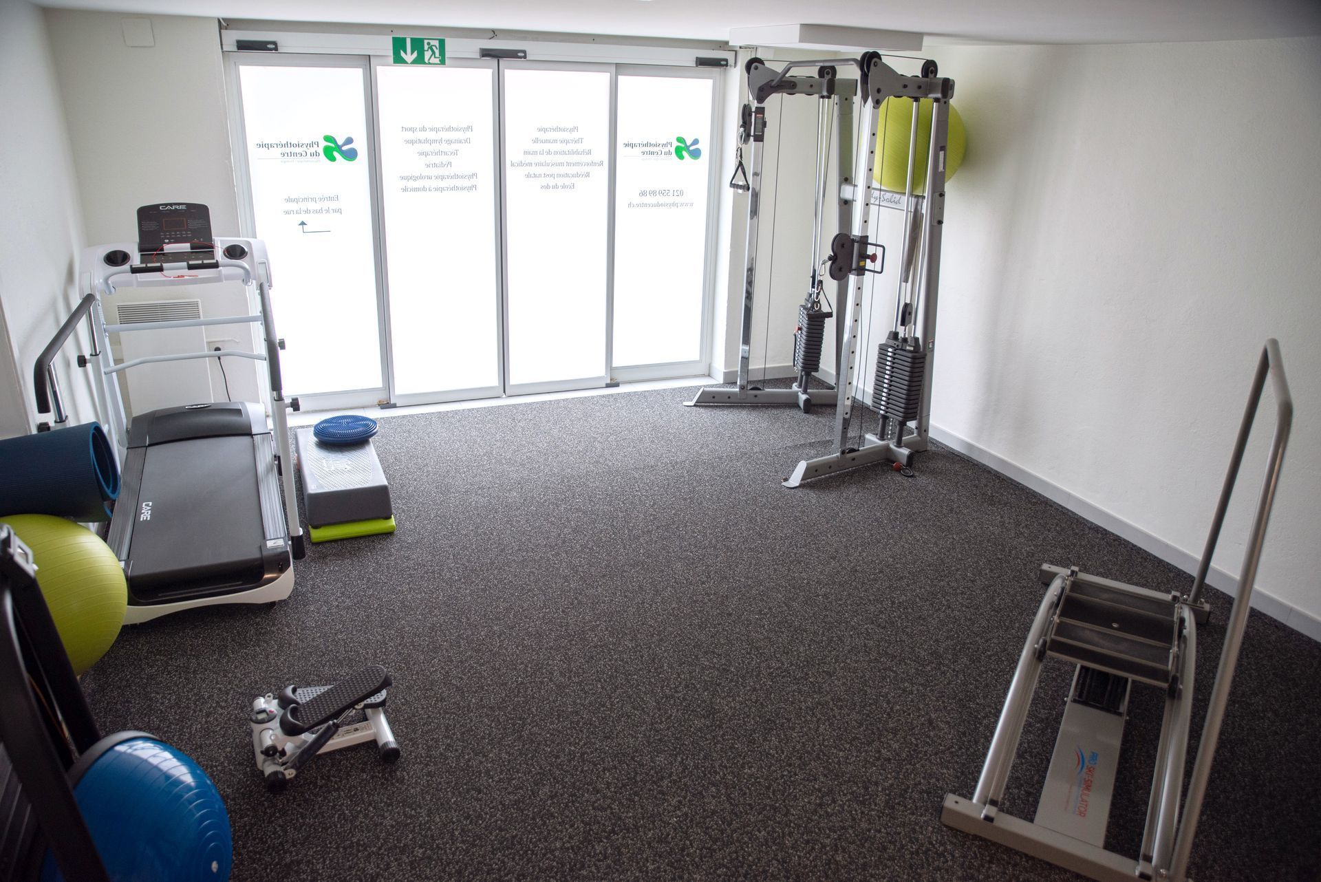 Salle de sport équipée d'appareils de musculation, dont une machine à haltères.