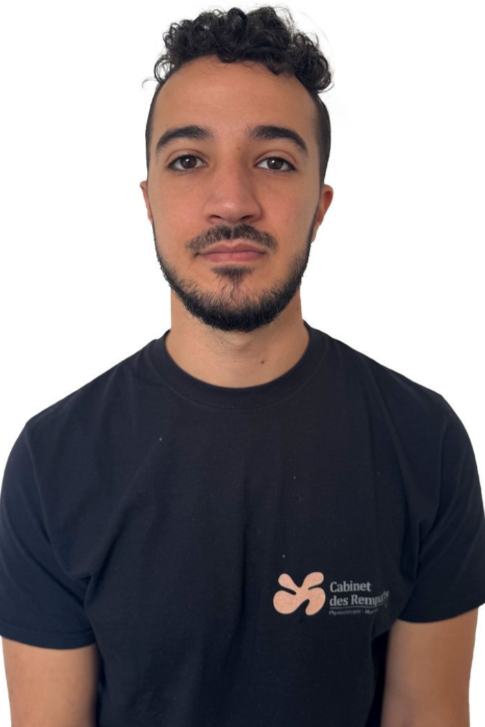 Un homme portant un t-shirt foncé avec un logo regarde droit dans l'objectif.