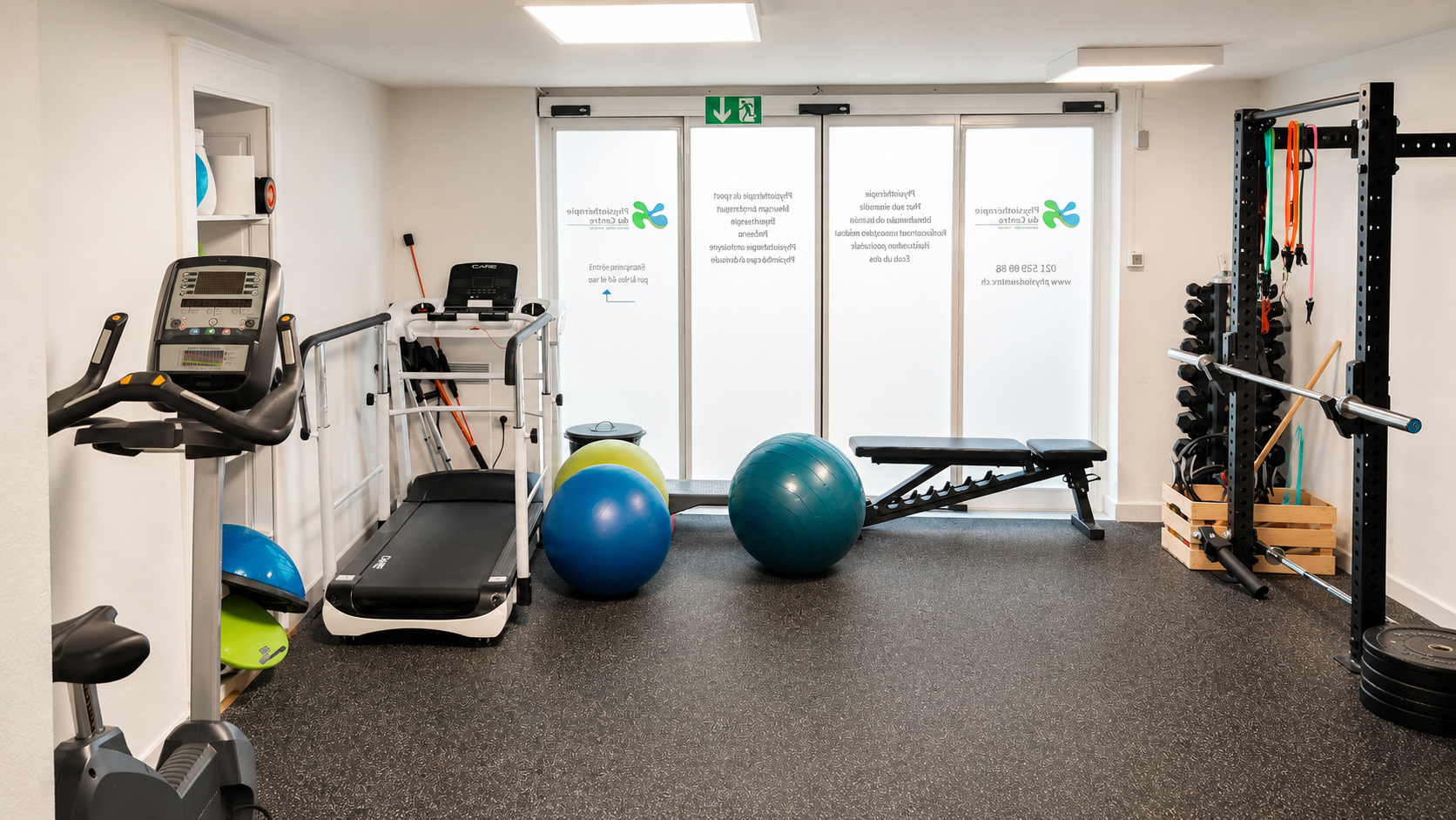 Salle de sport lumineuse avec tapis roulant, ballons de stabilité, haltères et appareils de musculation