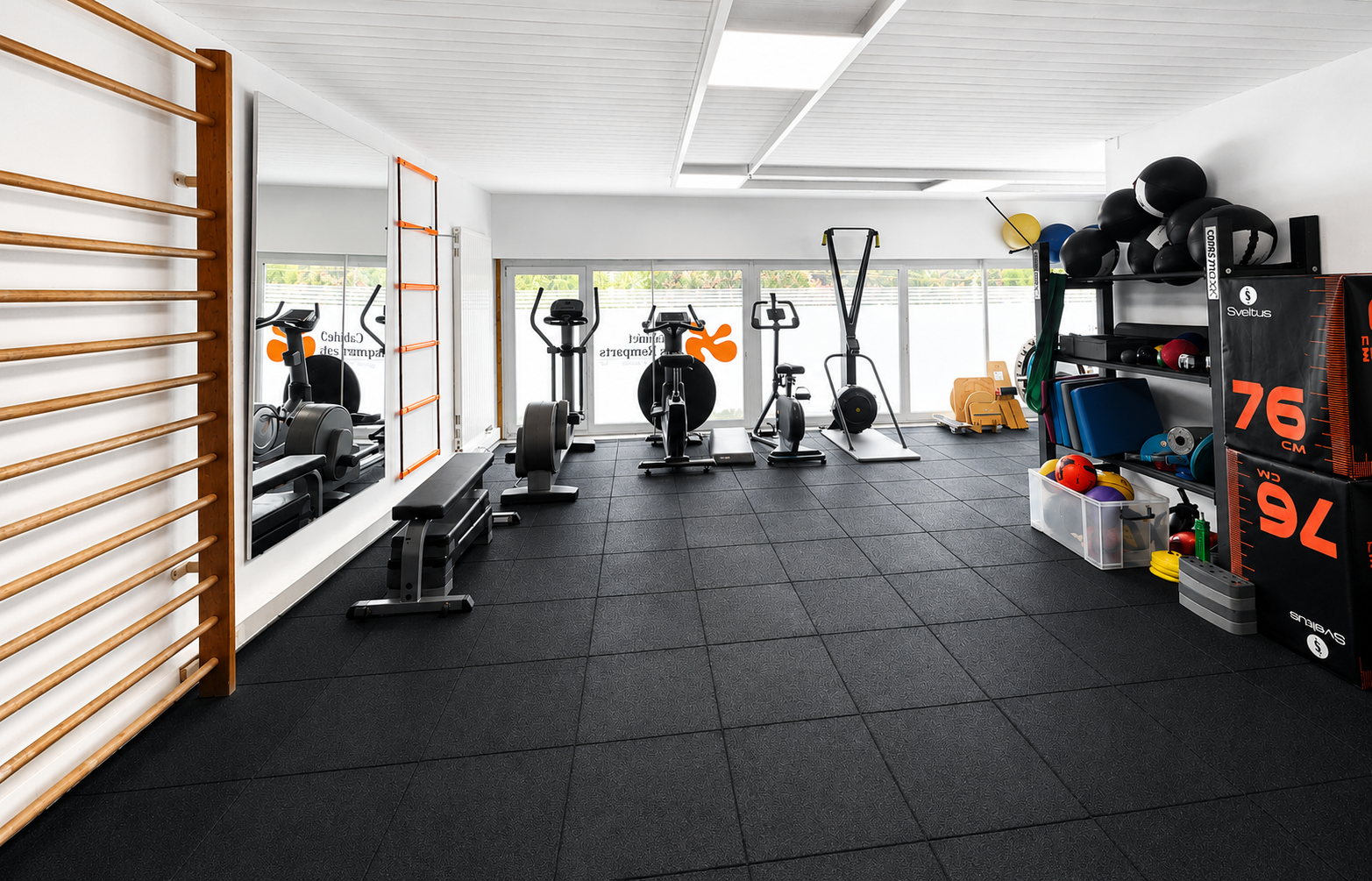 Salle de sport lumineuse à domicile avec vélos d'exercice, haltères et sol en caoutchouc noir