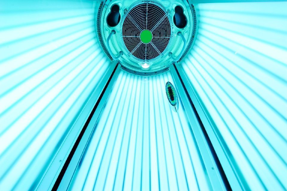 Innenansicht eines Solariums, aus dem hellblaues Licht von den Lampen ausgeht.