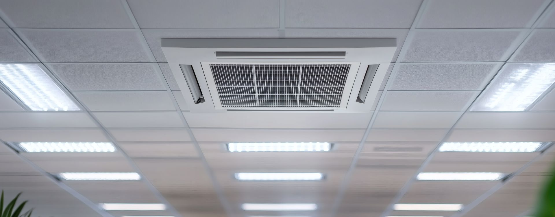 Des mains utilisent un tournevis pour réparer un climatiseur mural blanc.
