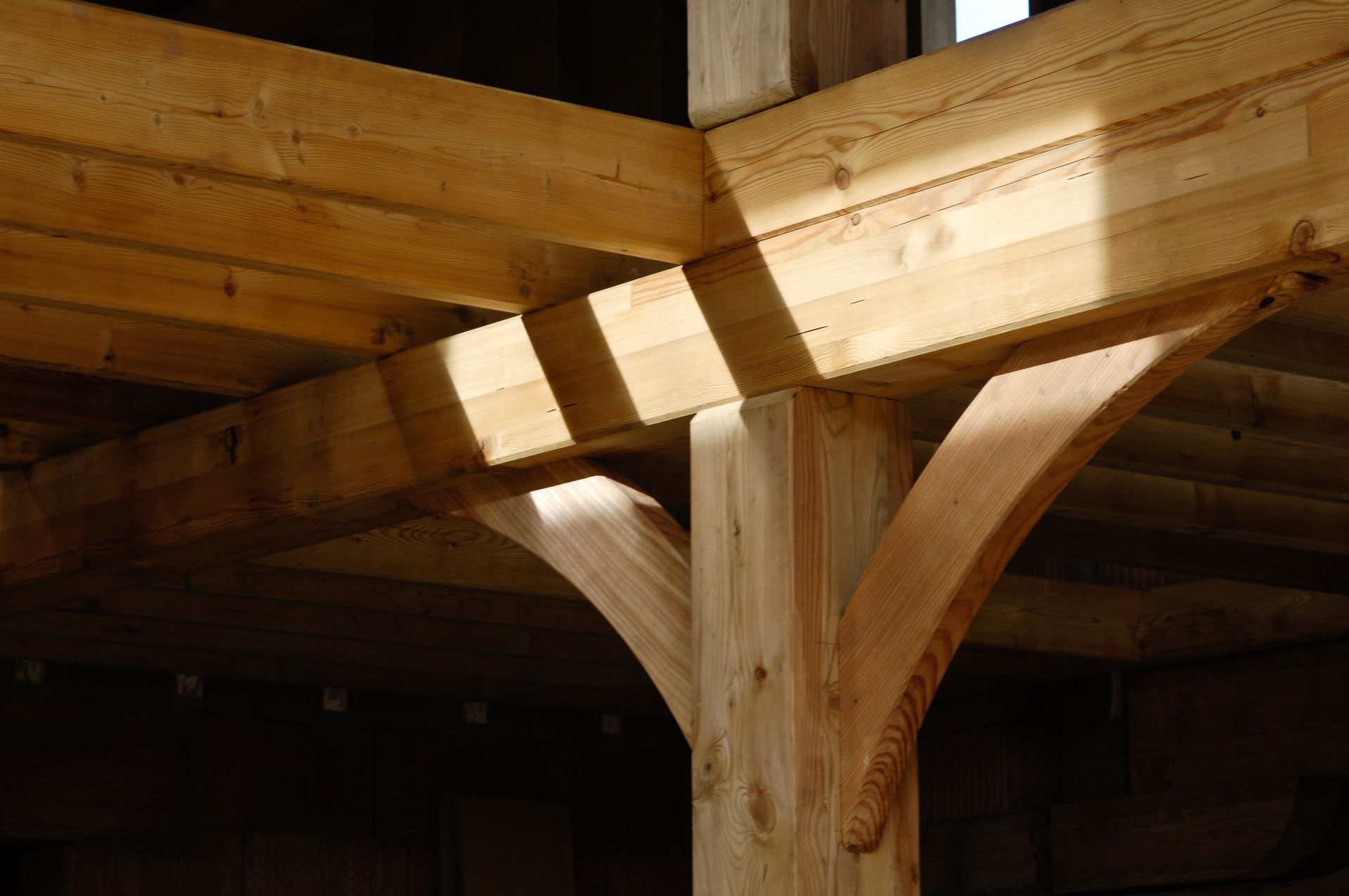 Poutres en bois d'une structure, comprenant un poteau vertical avec des supports incurvés.