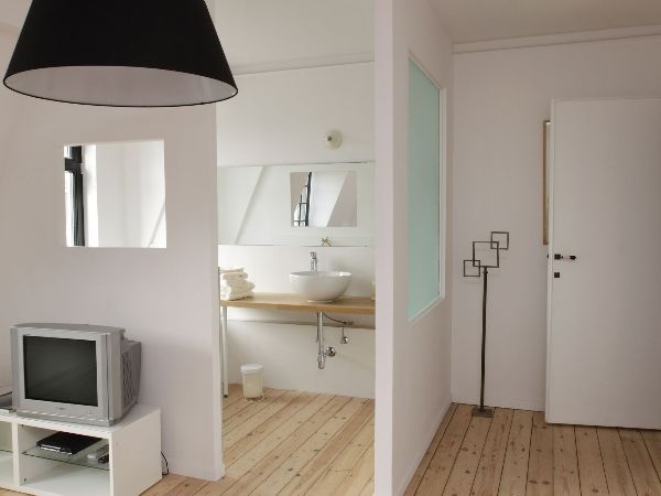 Cloison blanche séparant l'entrée de l'appartement et la salle de bains