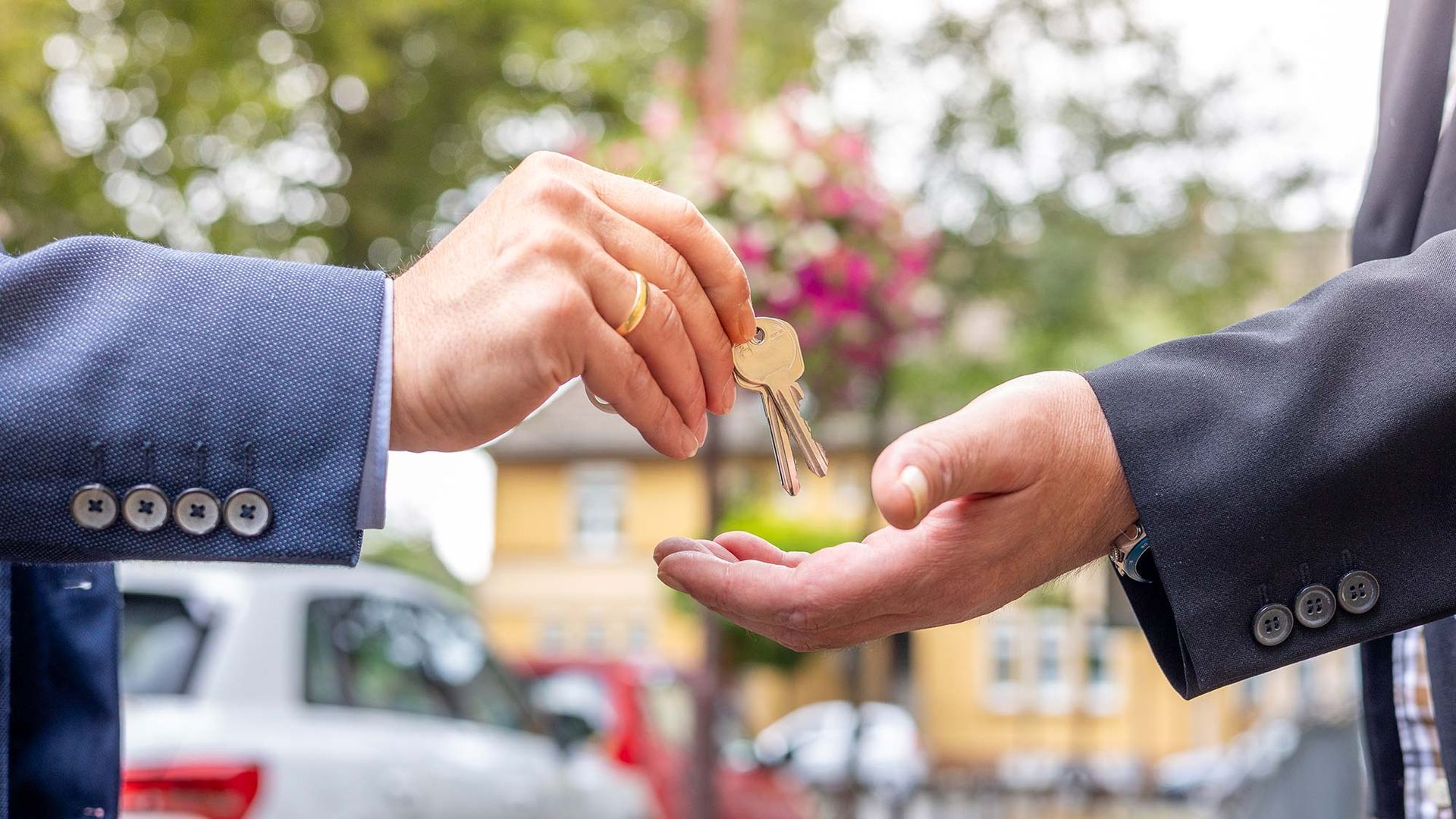 Ein Mann gibt einem anderen Mann einen Autoschlüssel.