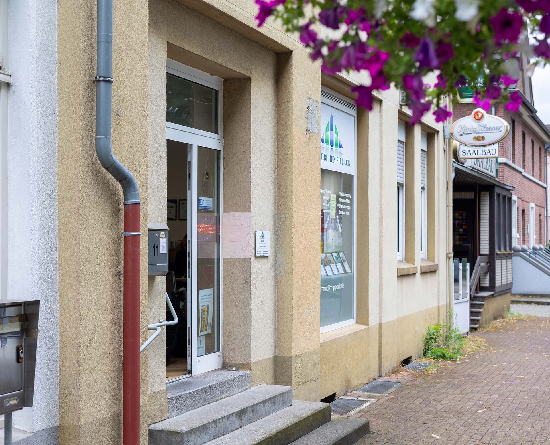 Ein Gebäude mit lila Blumen davor