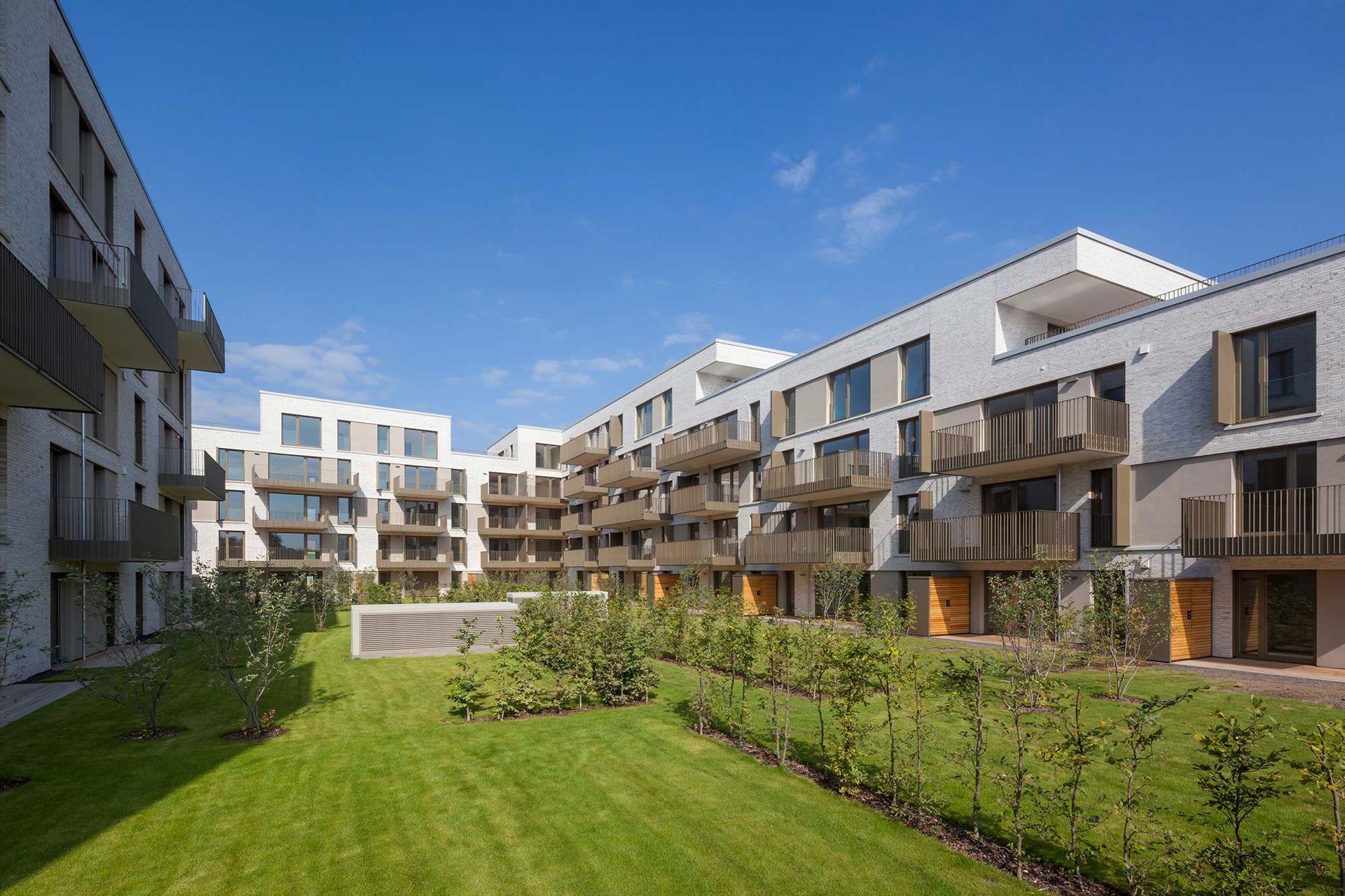 Ein großes Wohnhaus mit einem üppigen grünen Rasen davor.