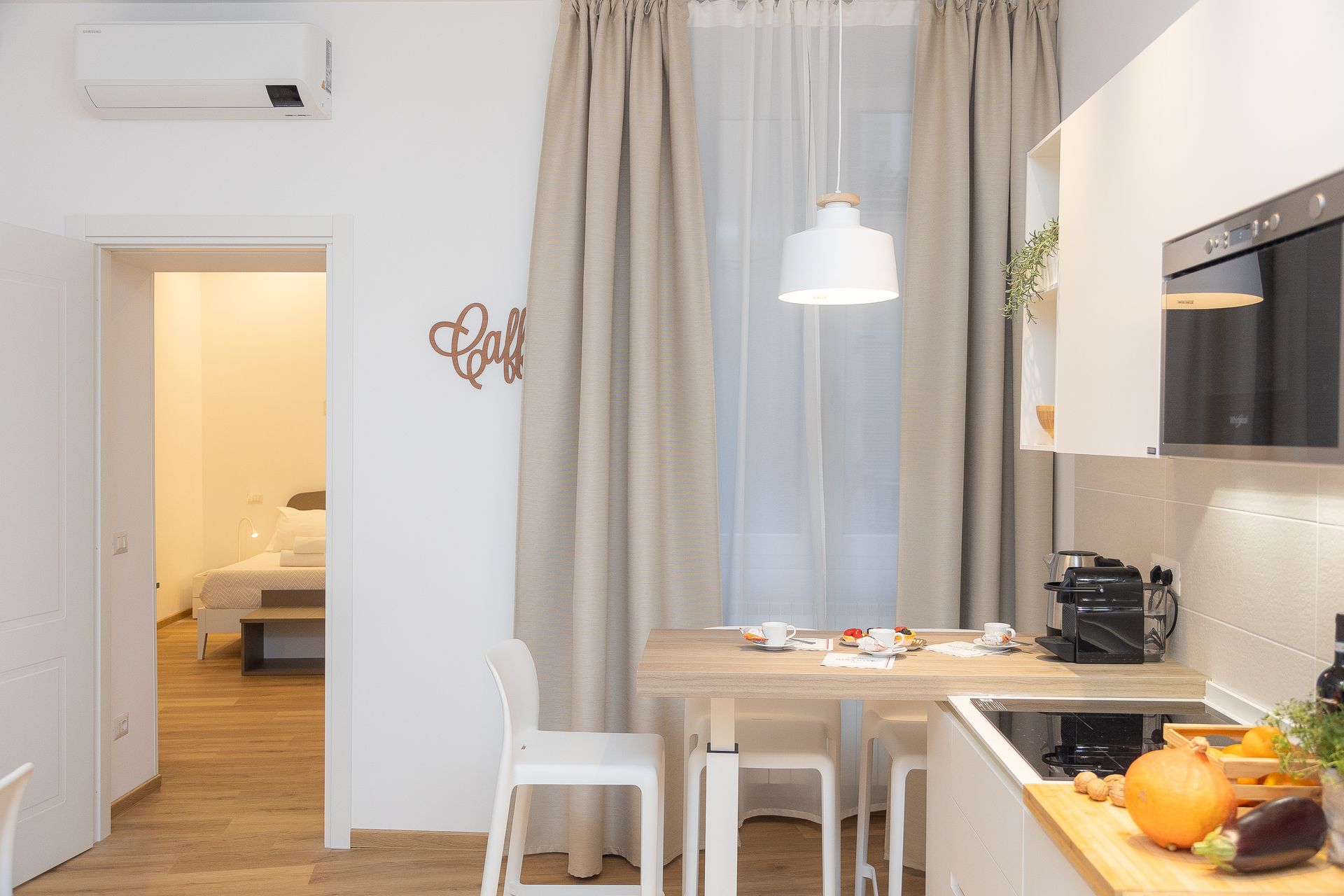 A kitchen with a table and chairs and a sign on the wall that says love.
