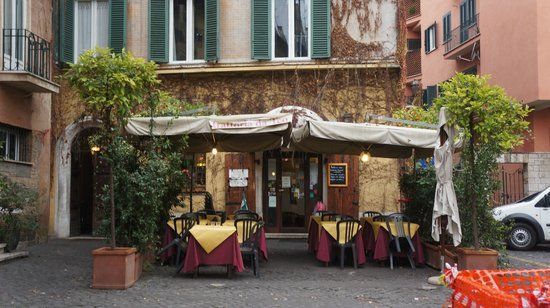 A restaurant with tables and chairs outside of it.
