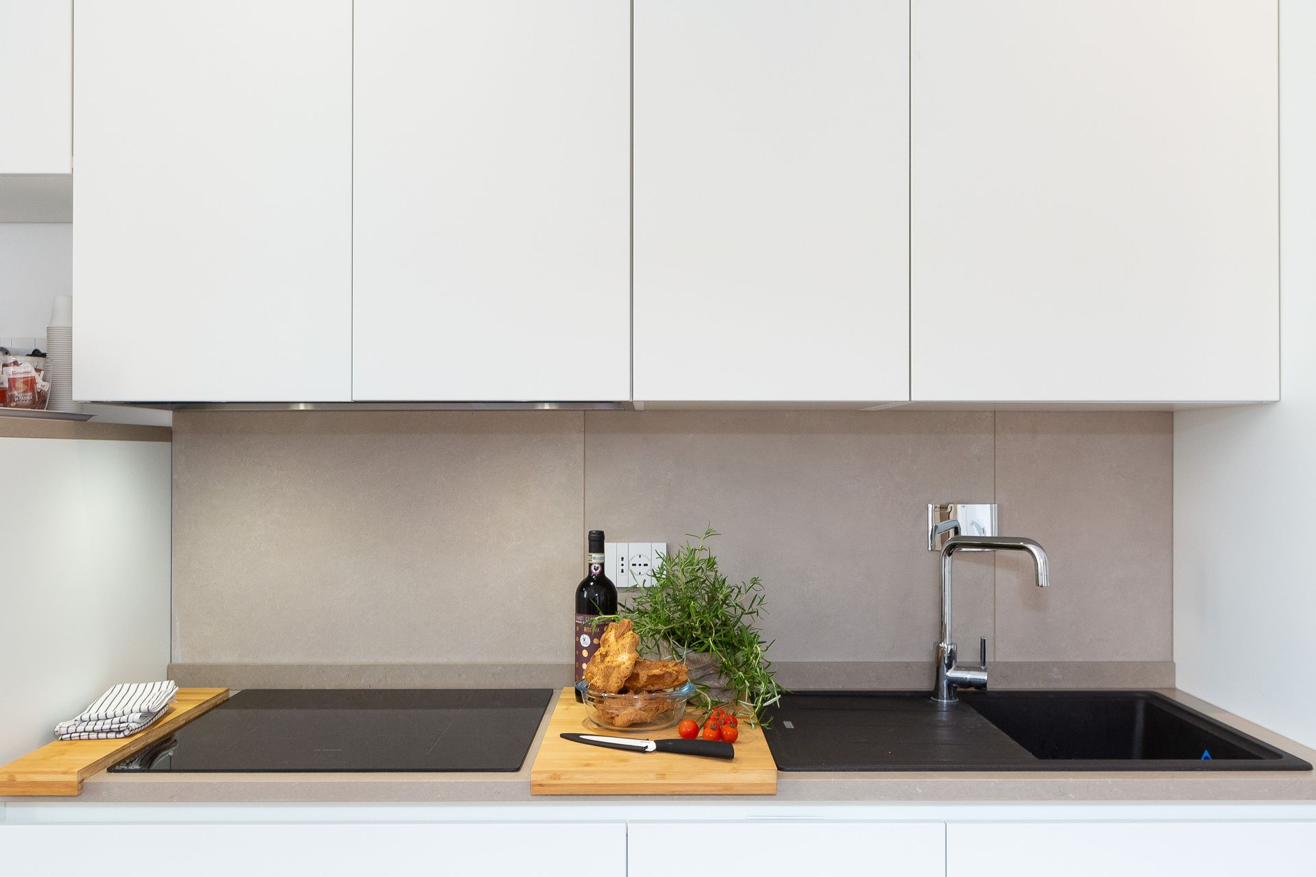 A kitchen with a stove top oven , sink , and cutting board.