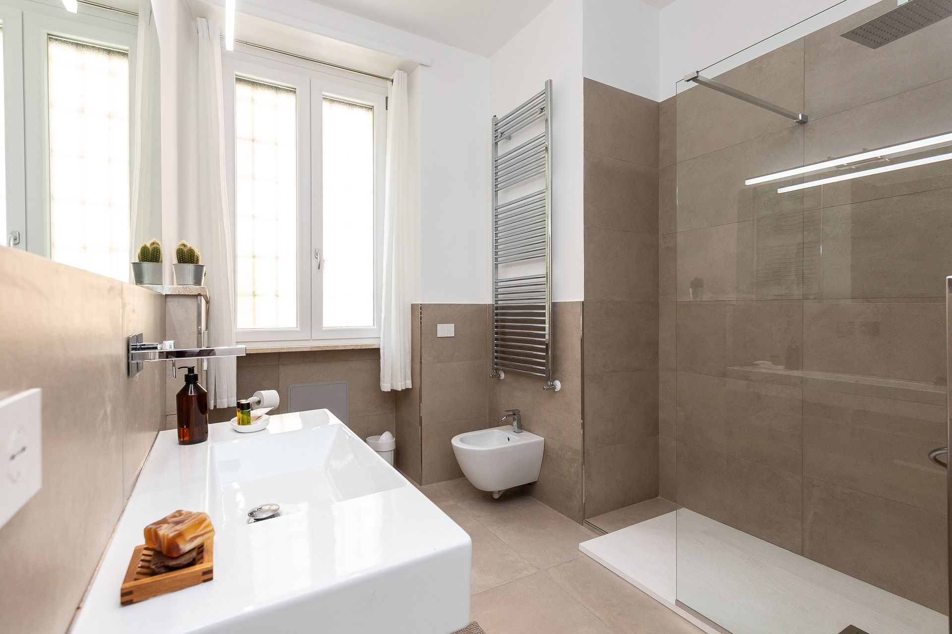 A bathroom with a sink , toilet and walk in shower.