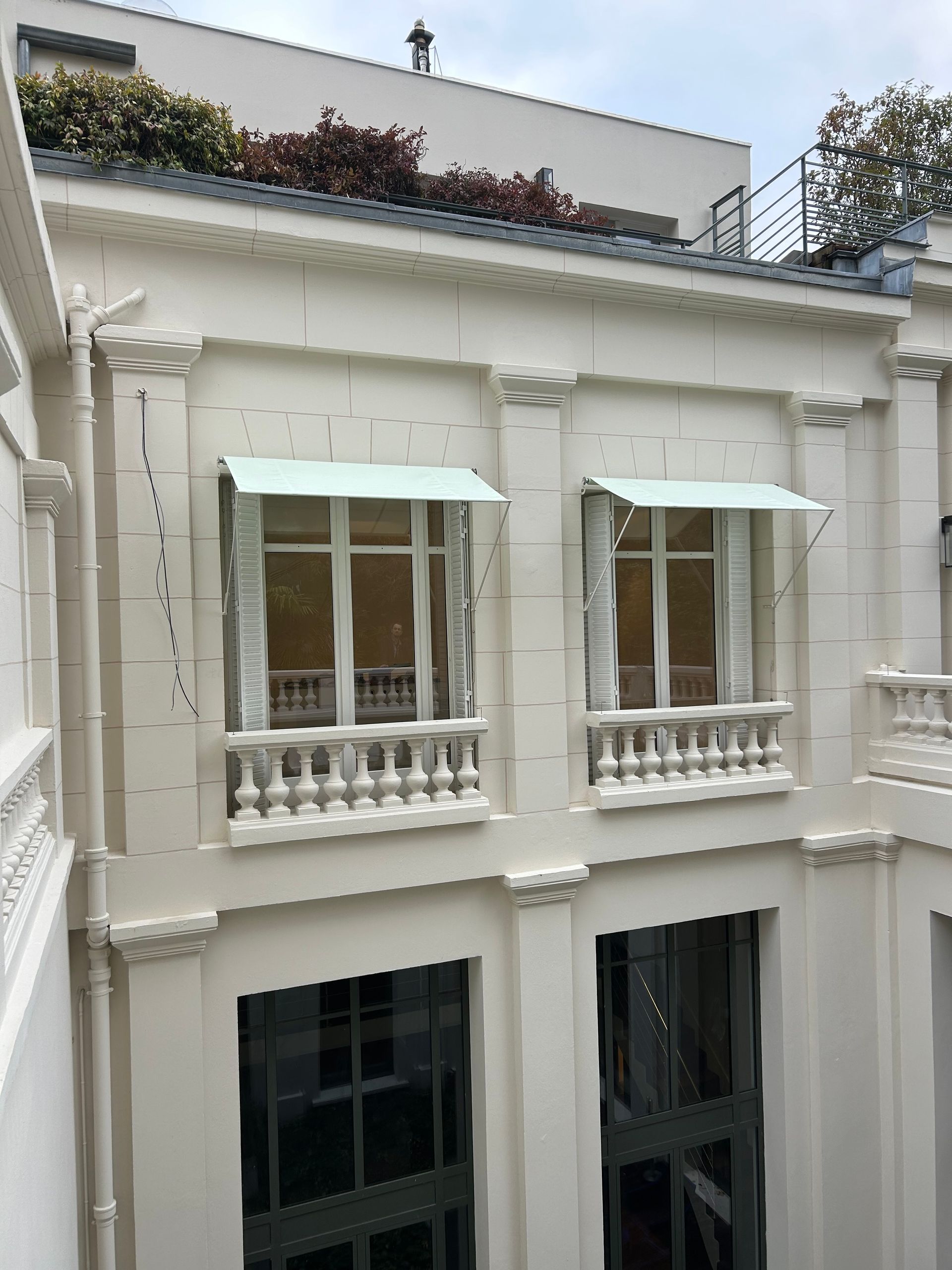 Deux fenêtres avec des stores individuels blancs