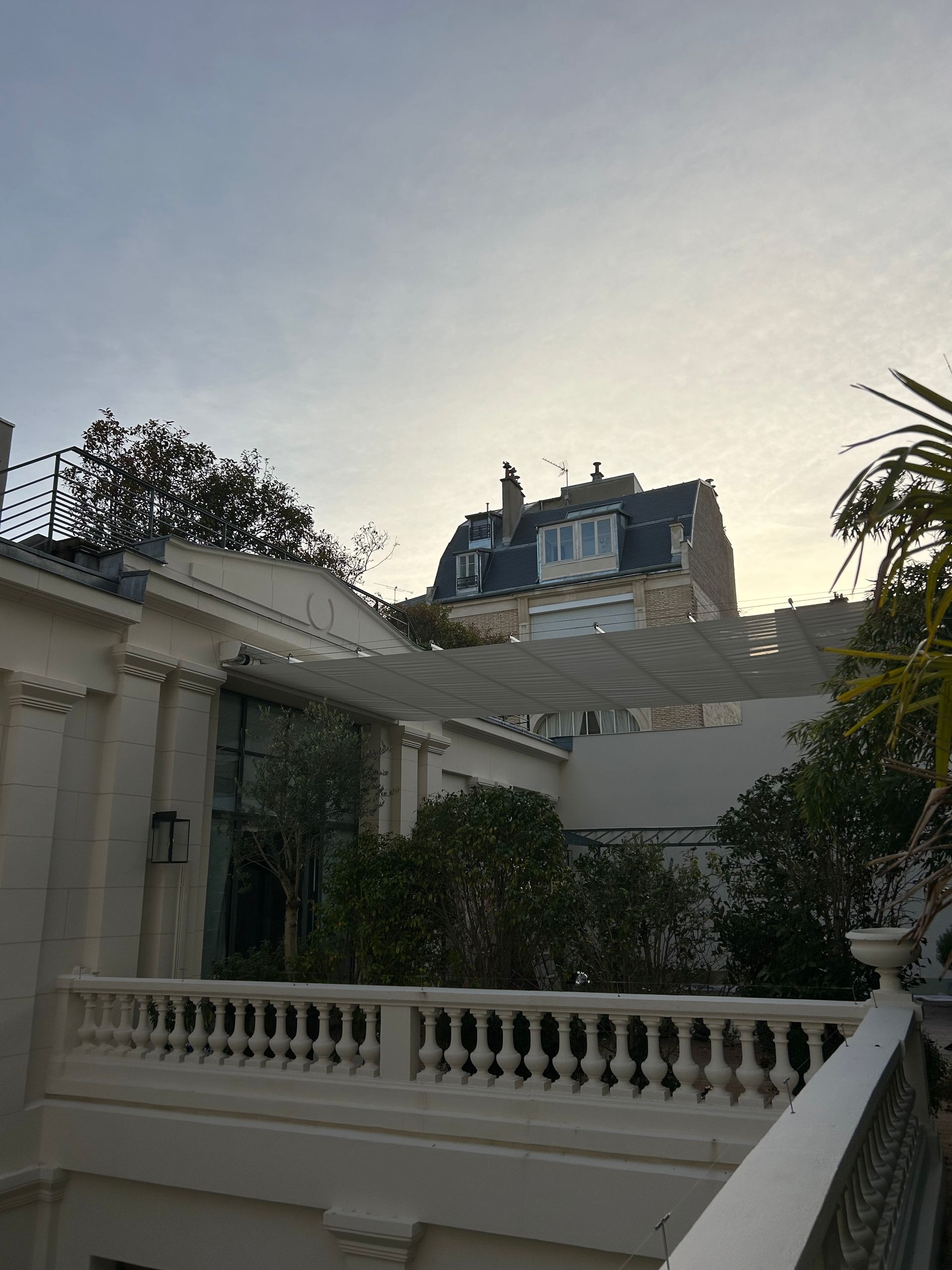 Un store blanc devant une maison hausmanienne