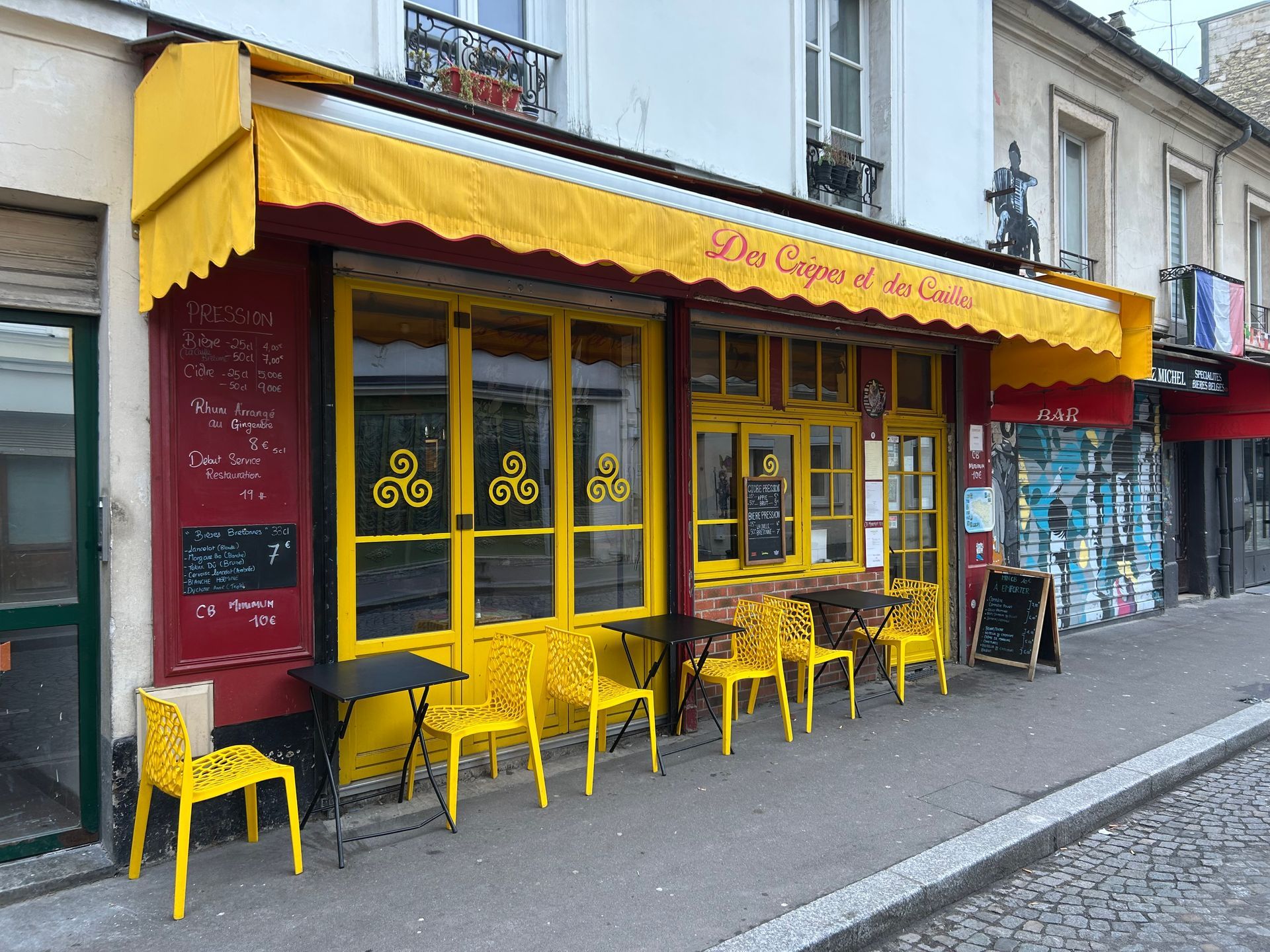 Un store jaune au dessus d'une devanture rouge