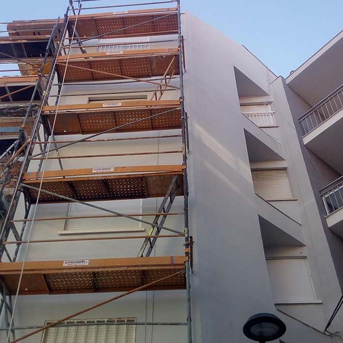 Un gran edificio con andamios a un lado.