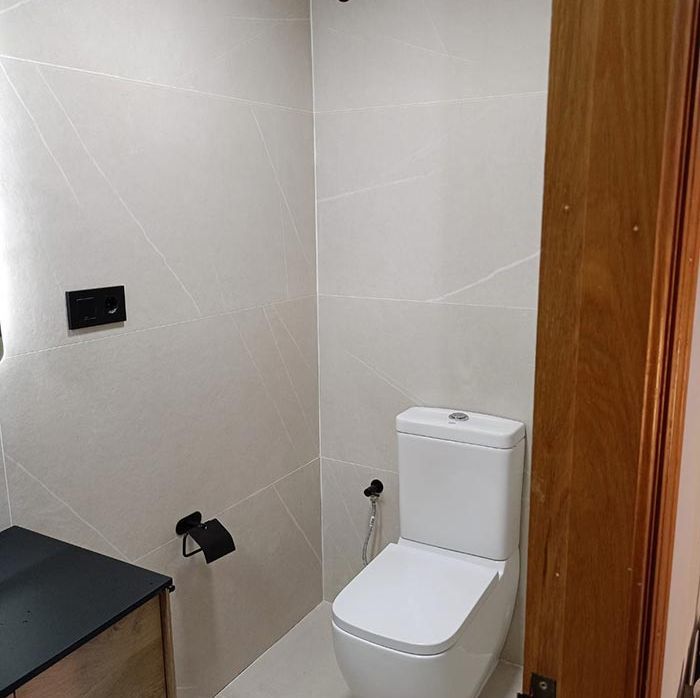 Un baño con inodoro, lavabo y espejo.