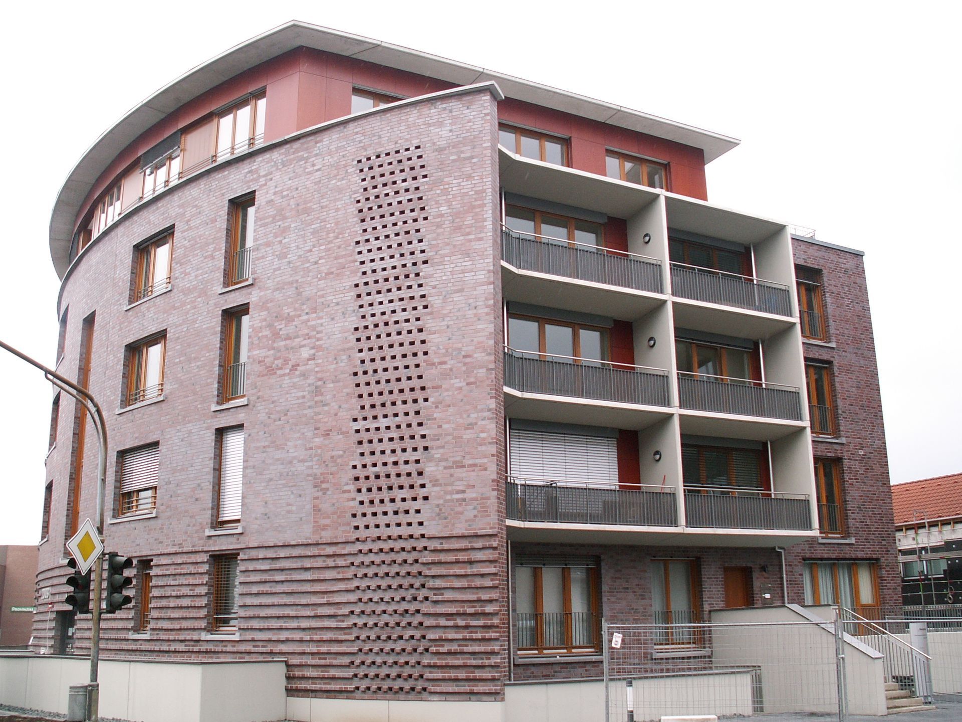 Organisch gebautes Gebäude mit vielen Fenstern, seitlich Balkone