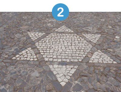 Mosaico de la estrella de David en una calle adoquinada.