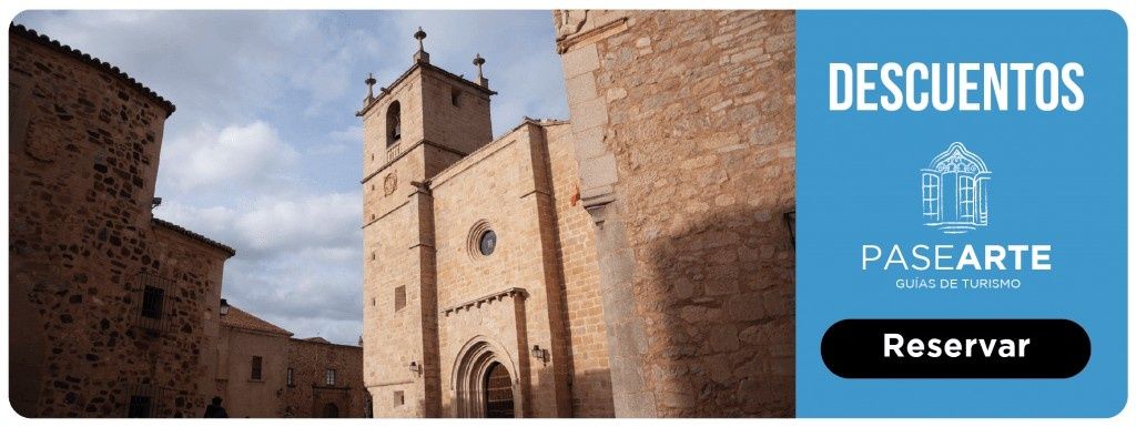 Fachada de un antiguo edificio de piedra con torre, apartado azul con 