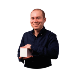 Hombre sosteniendo un cubo blanco, sonriendo, vistiendo una camisa azul oscuro con botones.