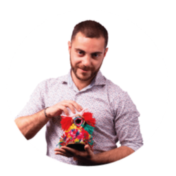 Hombre sosteniendo y mirando un objeto decorativo colorido.