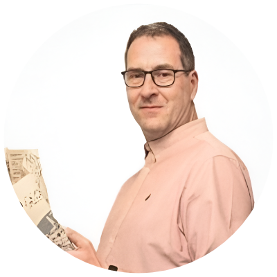 Hombre sosteniendo y mirando un objeto decorativo colorido.