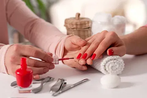 Una mujer se pinta las uñas en un salón de uñas.