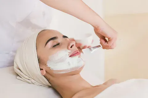 Una mujer está recibiendo un tratamiento facial en un spa.