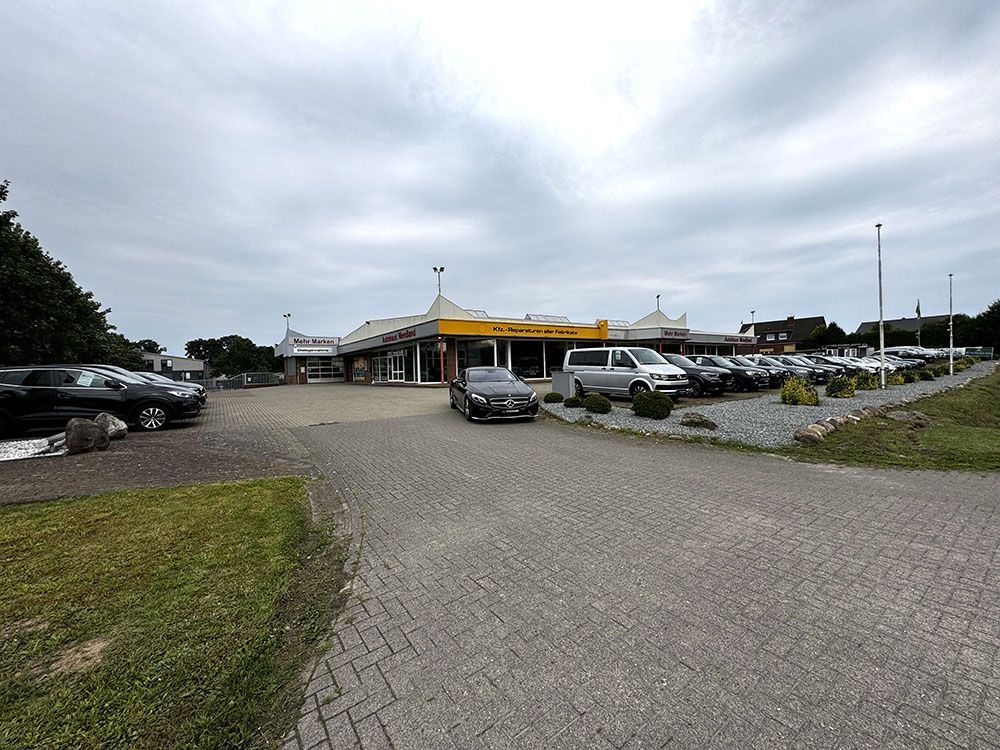 Vor einem Autohaus ist ein Auto geparkt.