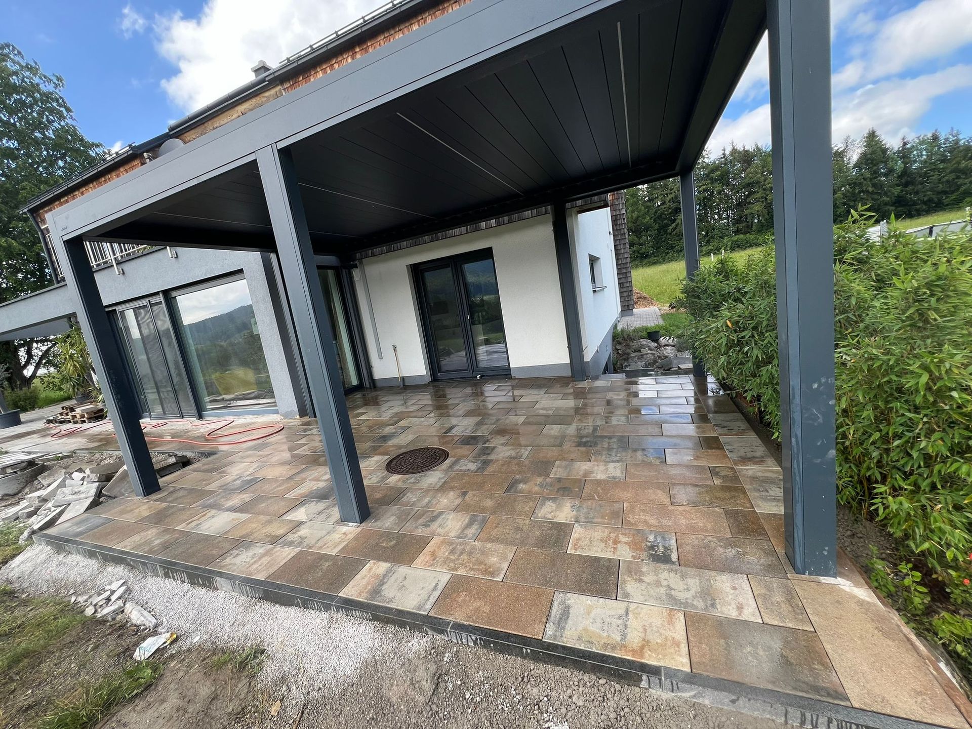 Ein Haus mit einer überdachten Terrasse davor.