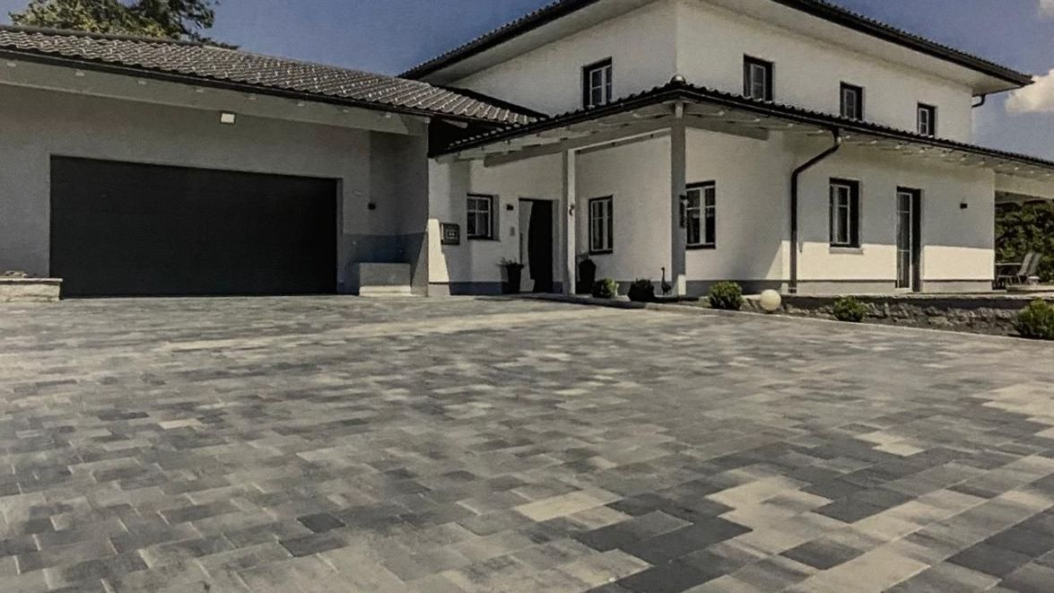 Ein großes weißes Haus mit einer Garage und einer Auffahrt davor.