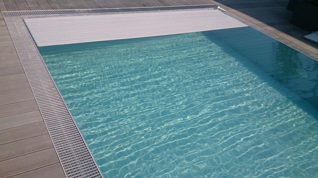Ein Schwimmbecken mit einer weißen Abdeckung an der Seite.