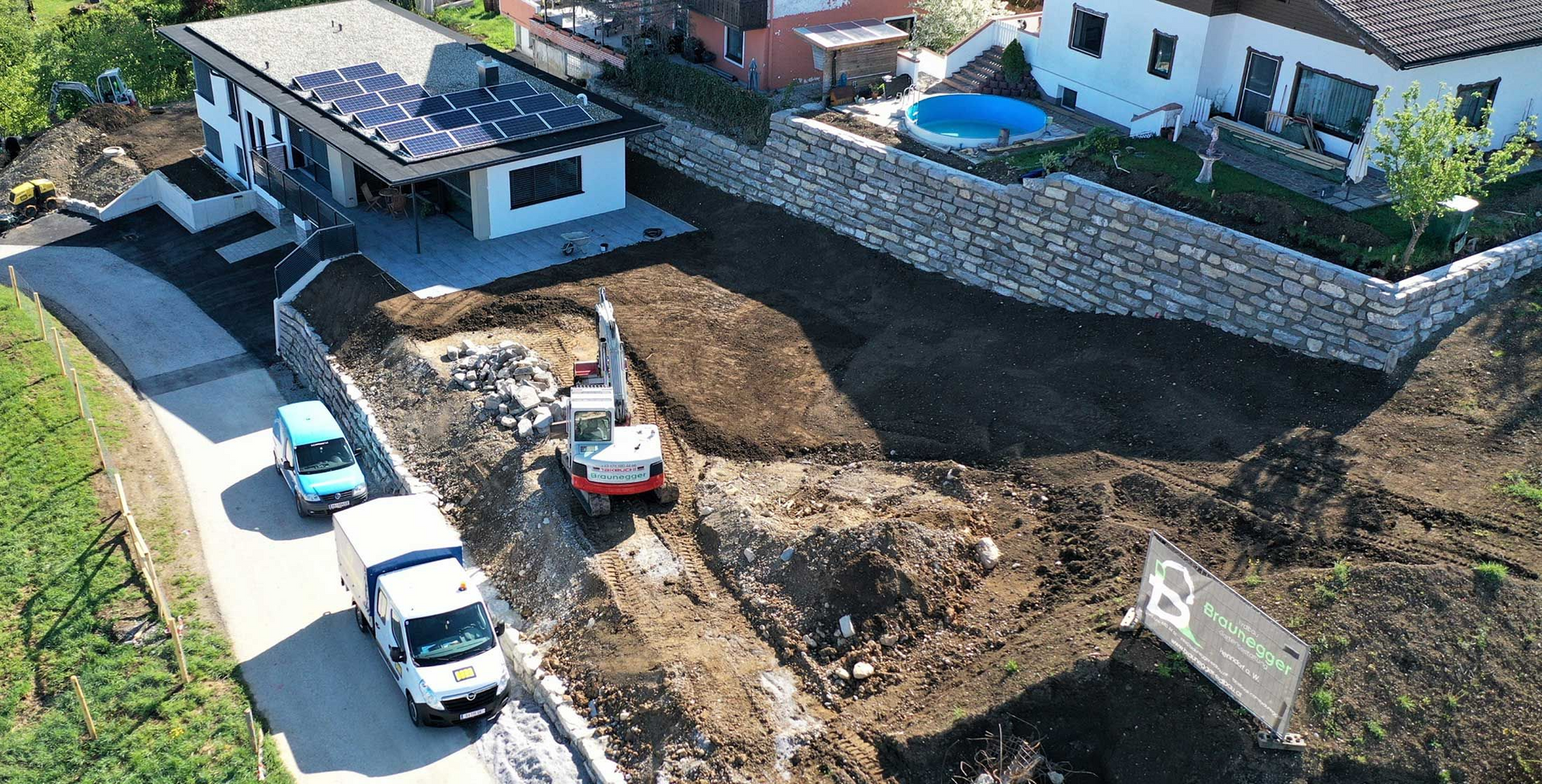 Eine Luftaufnahme einer Baustelle mit einem Haus im Hintergrund.