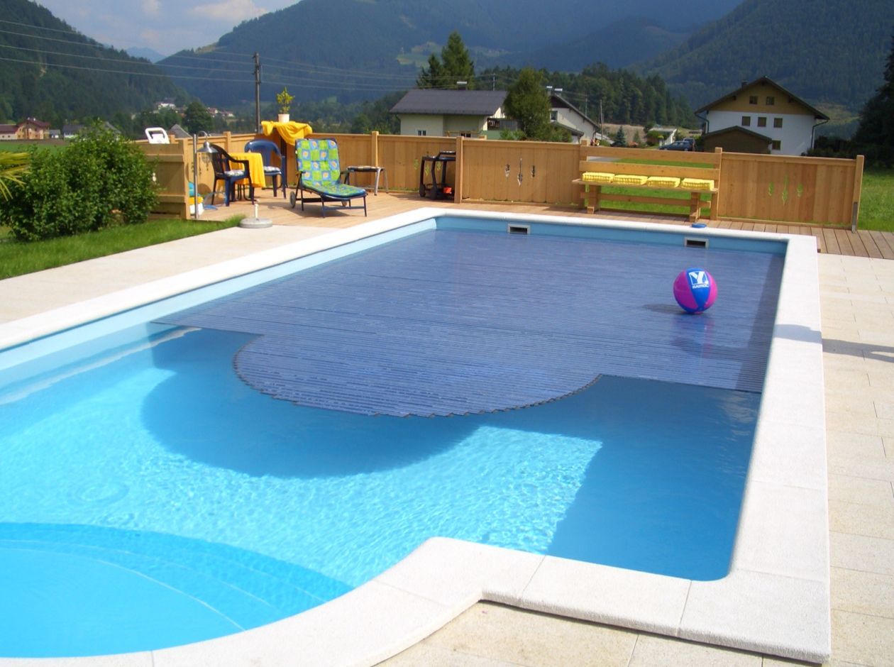 Ein Schwimmbecken mit einem Ball darin und Bergen im Hintergrund