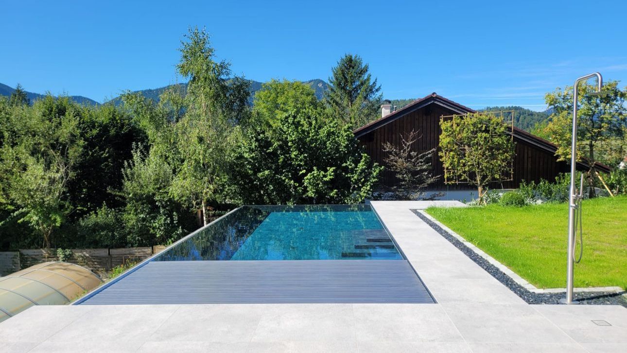 Im Hinterhof eines Hauses befindet sich ein großer Swimmingpool.