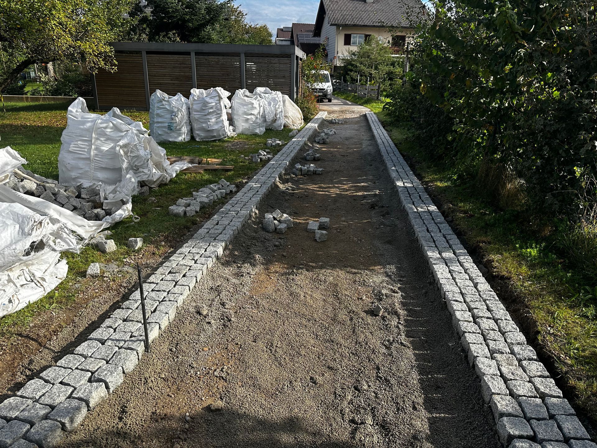 Vor einem Haus wird ein Steinweg gebaut.
