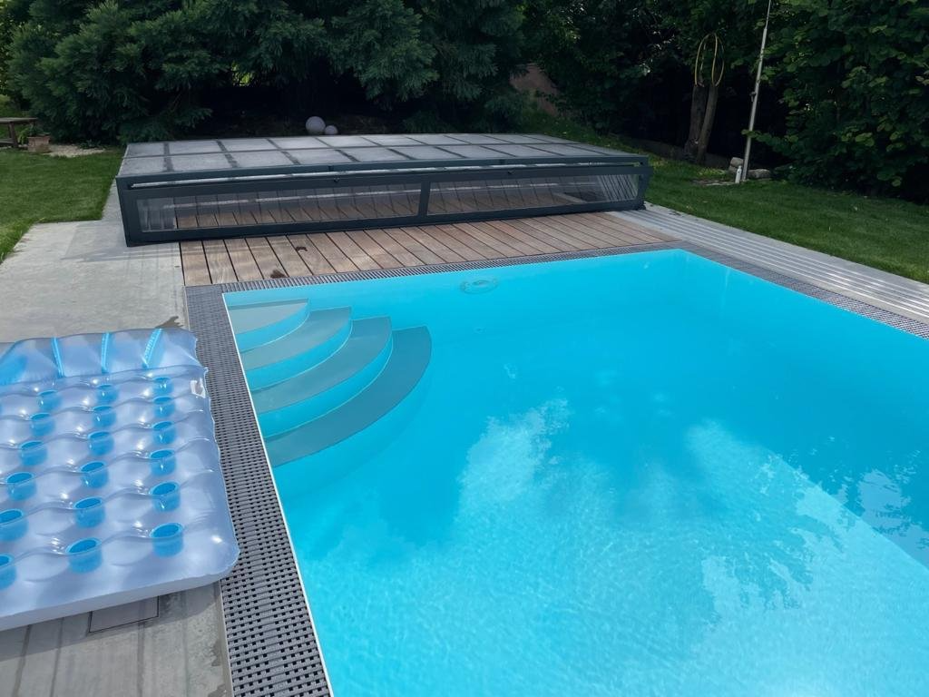 Ein Schwimmbecken mit einer Abdeckung und einem Floß im Wasser.