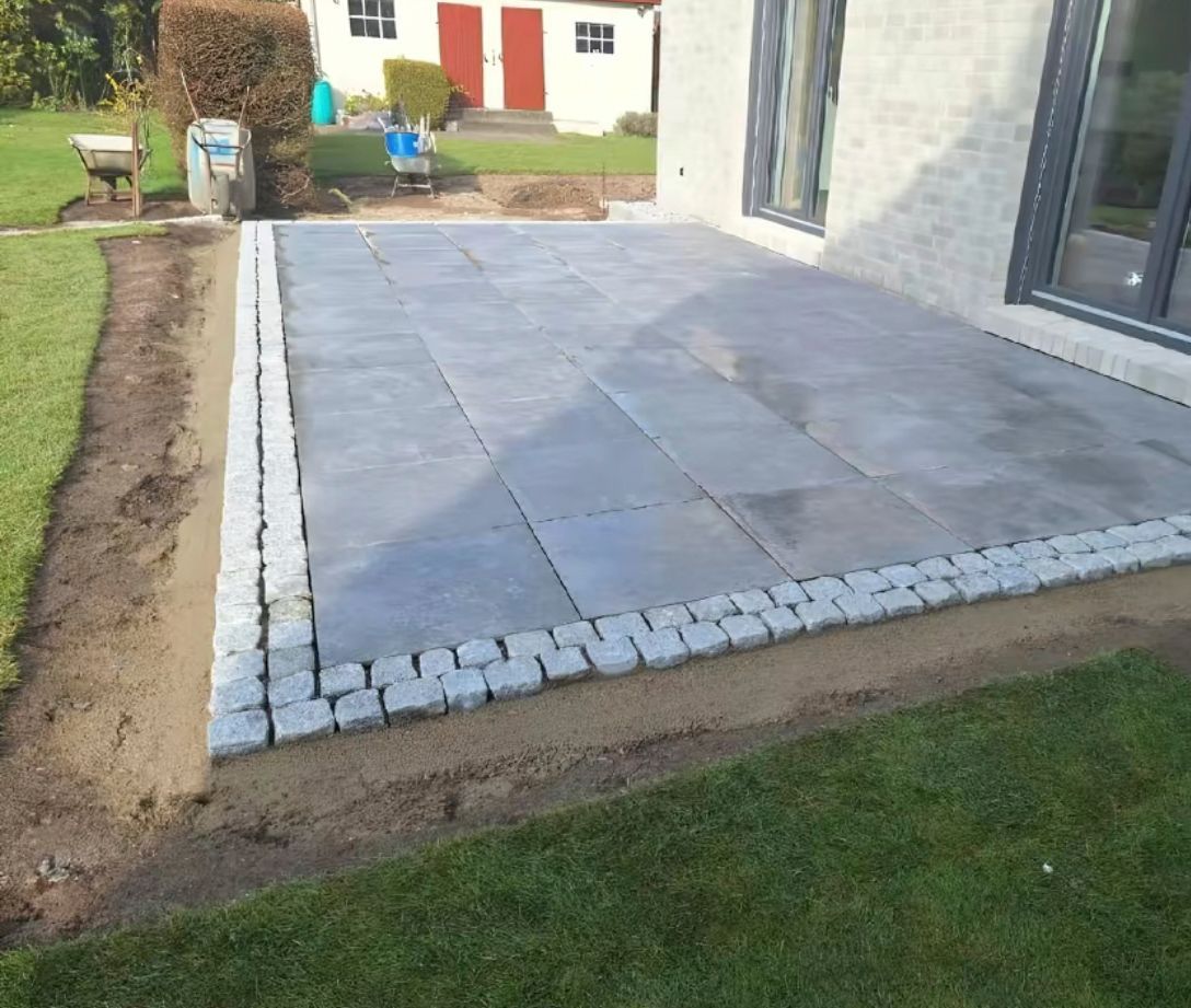 Im Hinterhof eines Hauses wird eine Terrasse gebaut.