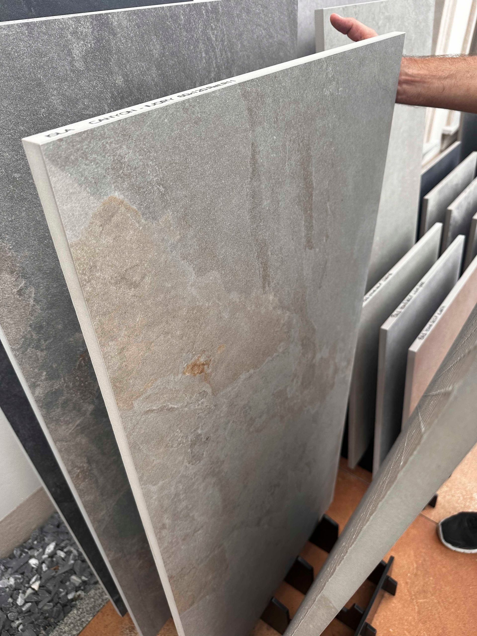 Eine Person hält ein großes Stück Fliese in der Hand.