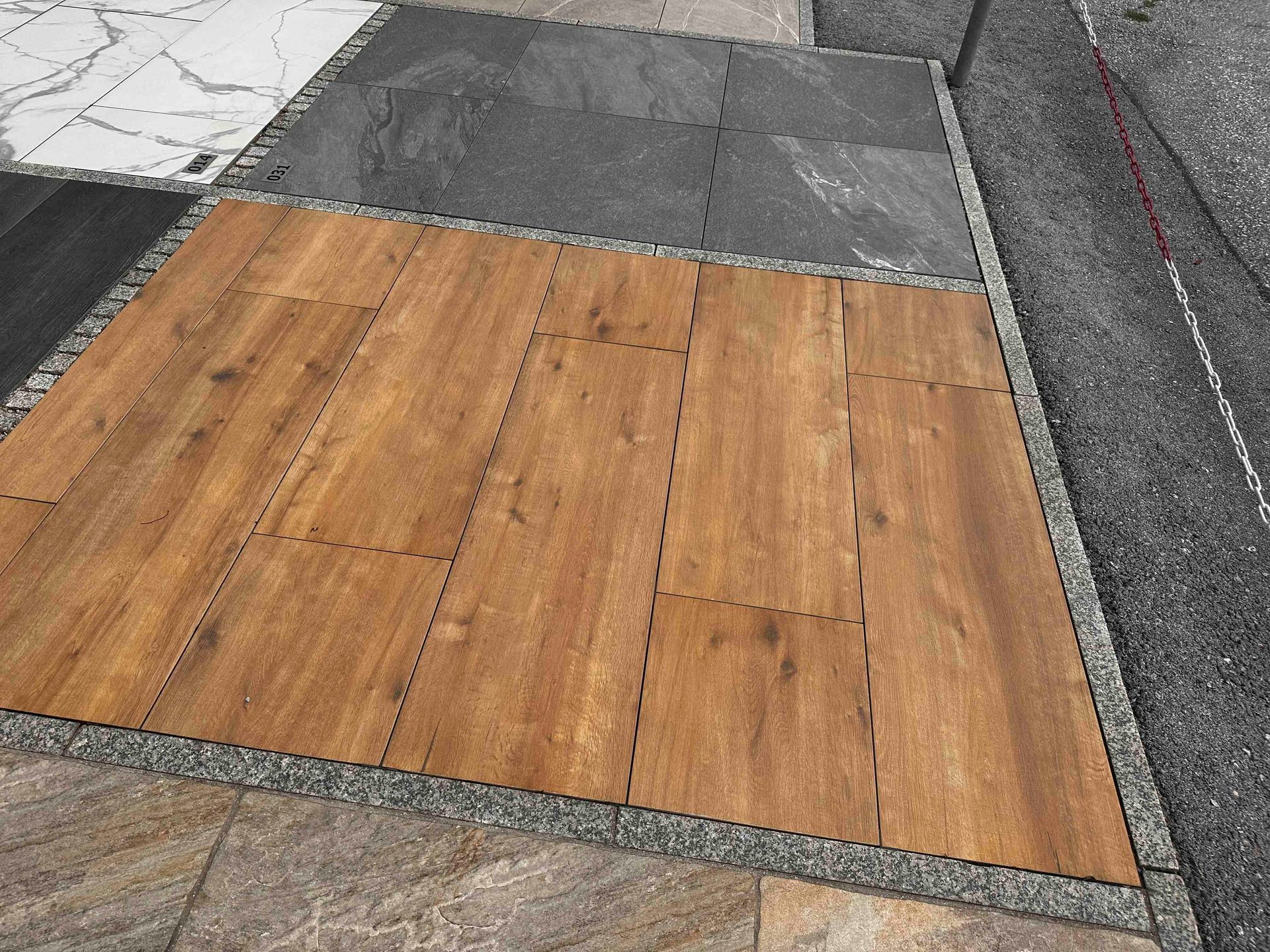 Ein Holzboden ist von verschiedenen Arten von Fliesen umgeben.