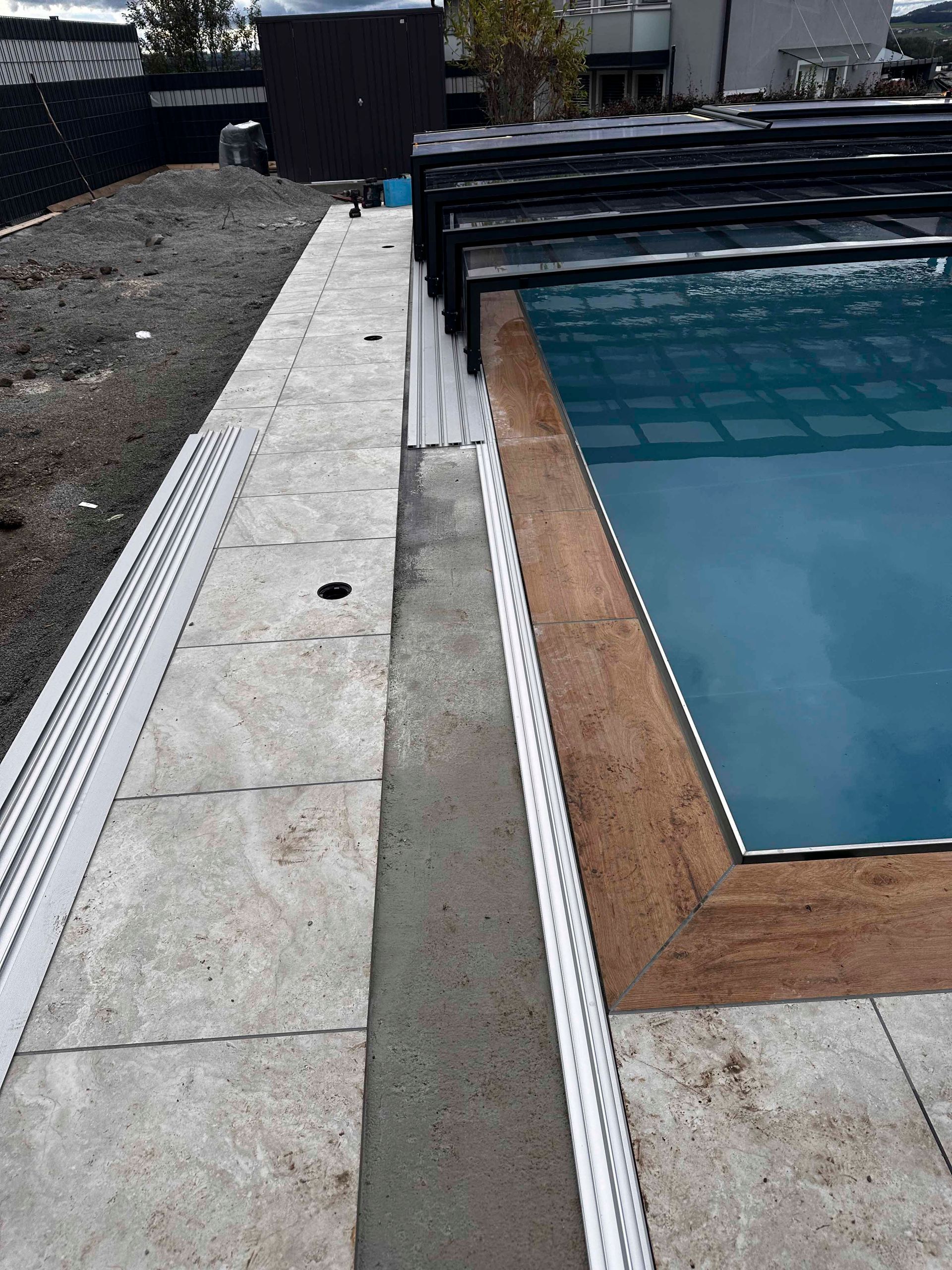 Im Hinterhof eines Hauses wird ein Swimmingpool gebaut.