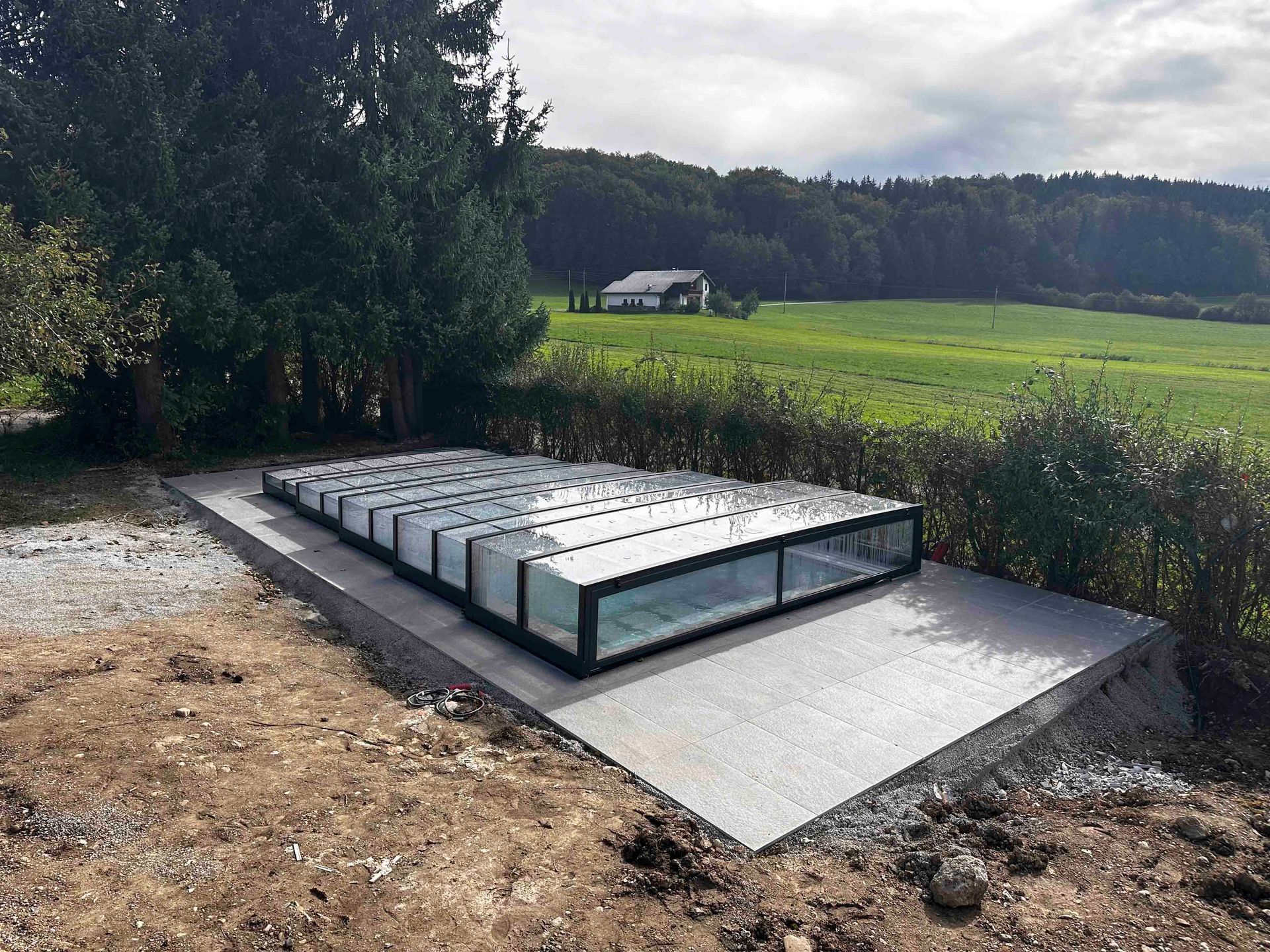 Mitten auf einem Feld wird ein Schwimmbad gebaut.