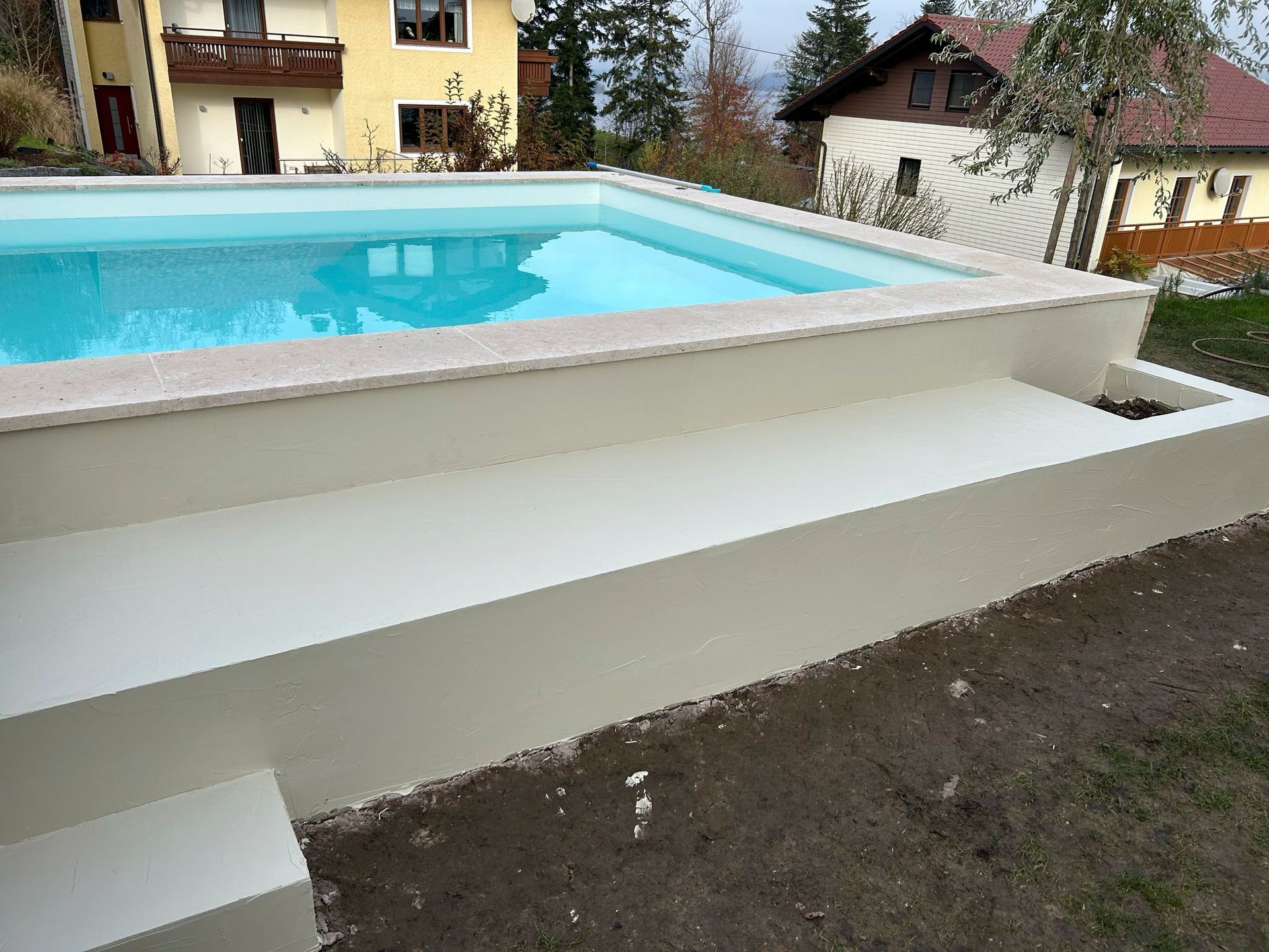 Im Hinterhof eines Hauses steht ein großer Swimmingpool.
